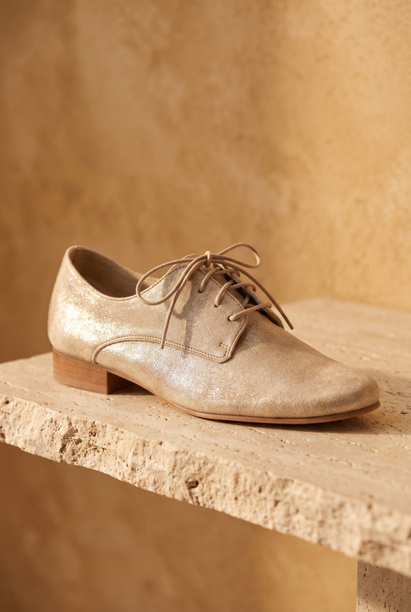 André Derby COMPLICE or en cuir véritable, couleur doré, avec lacets et talon plat. Style chic et lumineux.