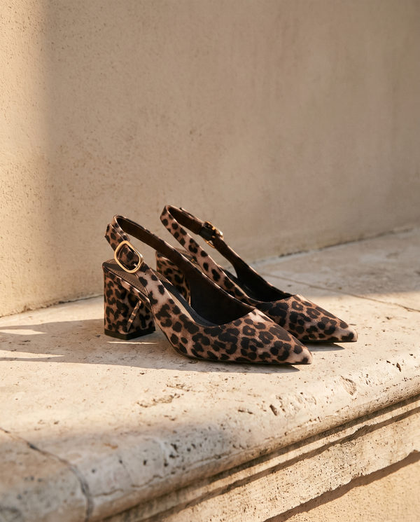 Paire de slingbacks THAÏS imprimé léopard posée sur une marche en pierre — A by André