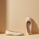 André ecru leather ballet flats with a square toe and delicate bow detail. Comfortable and chic.