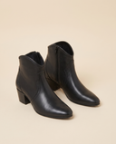 Boots ALIENA noires debout sur fond beige