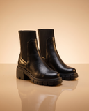 Boots ANDREAS noires debout sur fond beige