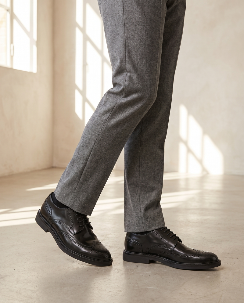 Derby AVENTIN noir porté, pantalon flanelle gris, sol béton clair