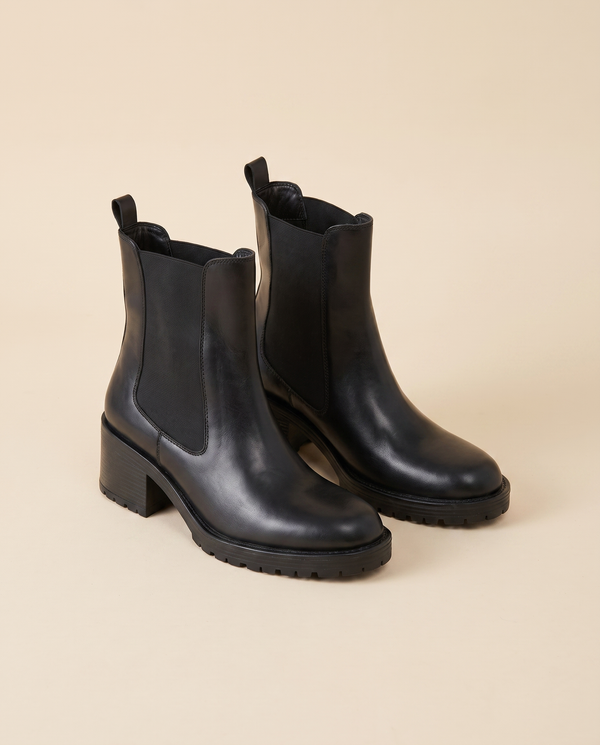 Boots BARBARA noir debout sur fond beige