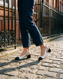 Slingback BRUNIE beige portée, gros plan, sur les pavés d'une rue londonienne