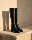 Paire de bottes CALIA noires posée sur une marche en pierre — André
