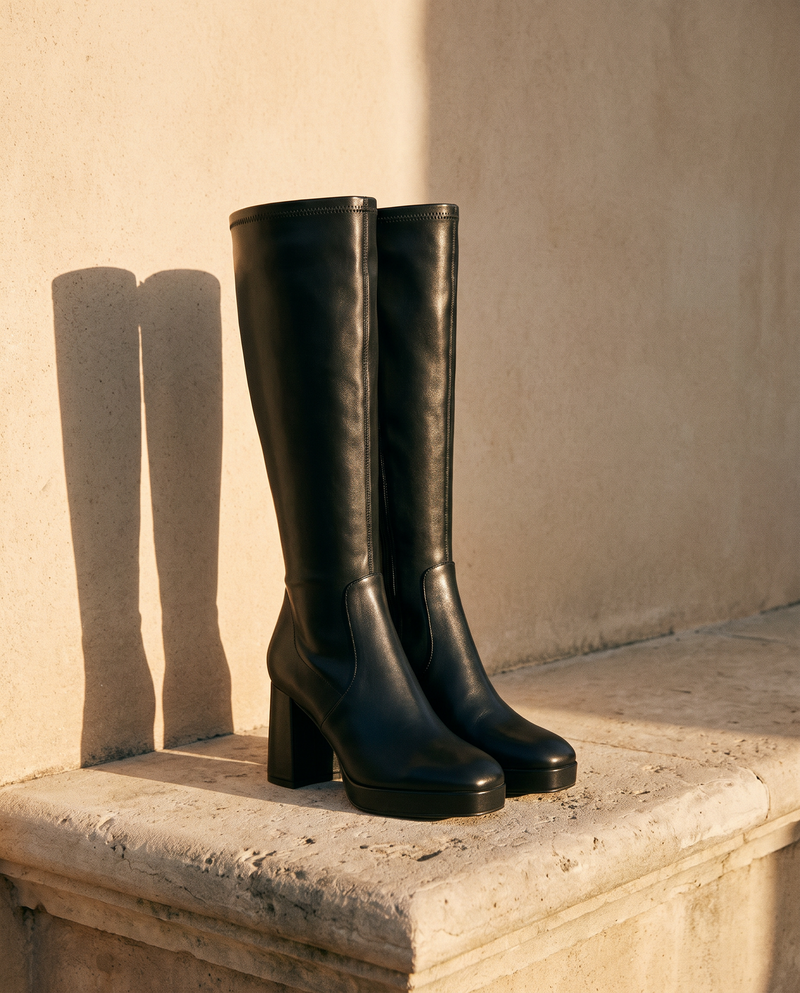 Paire de bottes CALIA noires posée sur une marche en pierre — André