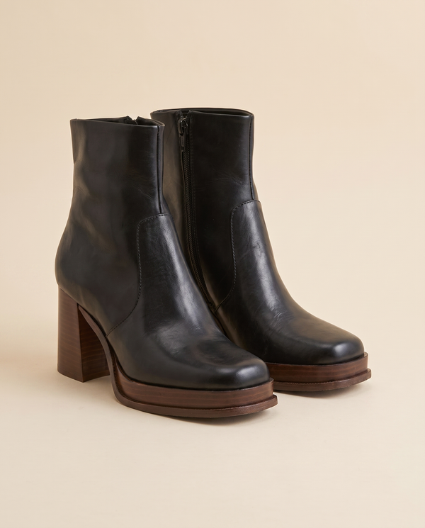 Boots CELESTE noir debout sur fond beige