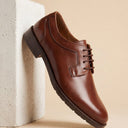 Chaussures homme André CERNY en cuir cognac, bout rond, fermeture à lacets, semelle crantée. Élégantes et polyvalentes.