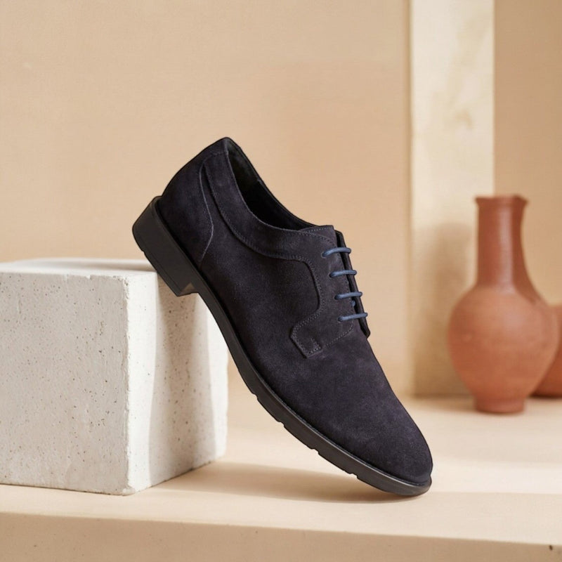 André Derby en cuir suède bleu marine, lacets bleus, semelle fine et légère, style moderne et polyvalent.