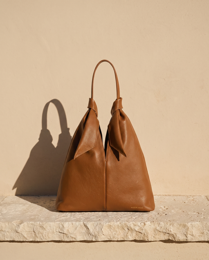 Sac DAUPHINE cognac Maison André sur une marche en pierre