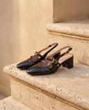 Slingback DEOTILLE noire posée sur une marche en pierre, mur enduit beige