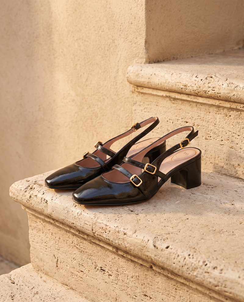 Slingback DEOTILLE noire posée sur une marche en pierre, mur enduit beige