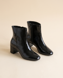 Boots DORISA noires debout sur fond beige