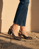 Gros plan sur les chevilles portant les slingbacks THAÏS imprimé léopard — A by André
