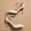 André escarpins en cuir beige à brides croisées et talon fin de 8,5 cm. Bout pointu et fermeture à la cheville.
