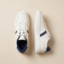 André baskets en cuir blanc avec rayures et lacets bleu marine, style décontracté et chic.