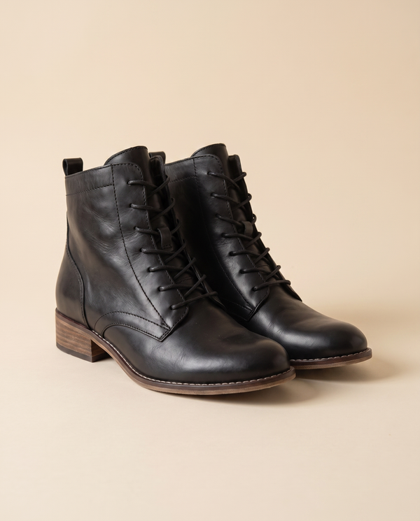 Boots GODILLOT noires debout sur fond beige