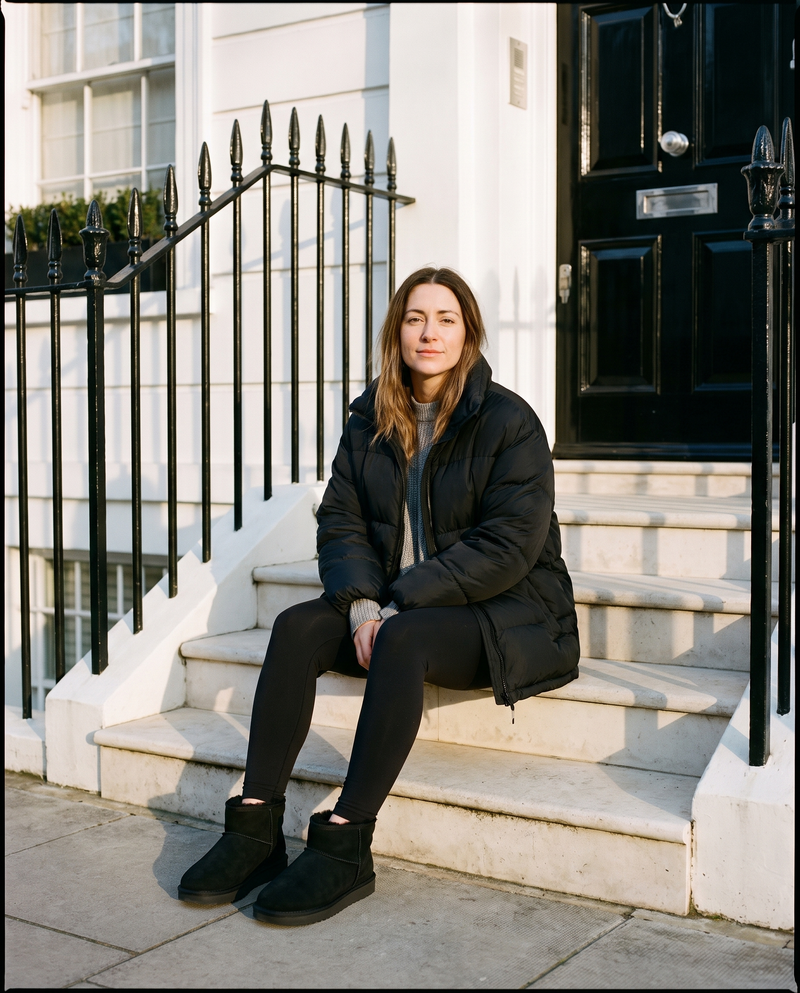 Boots fourrées ICECREAM noires portées, femme assise sur le perron d'une maison londonienne