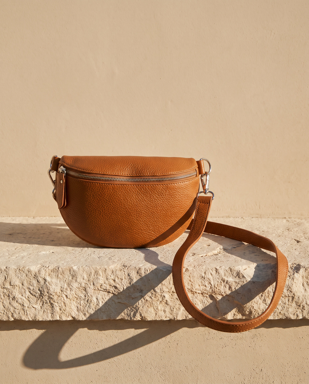 Sac banane ISLA cognac Maison André posé sur une marche en pierre