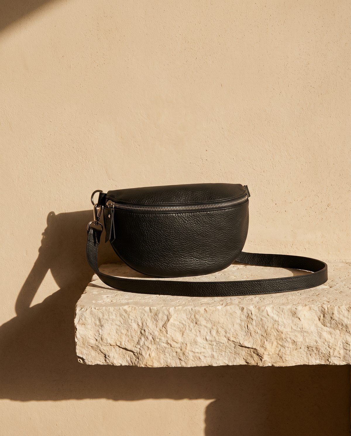 Sac banane ISLA noir Maison André sur une marche en pierre