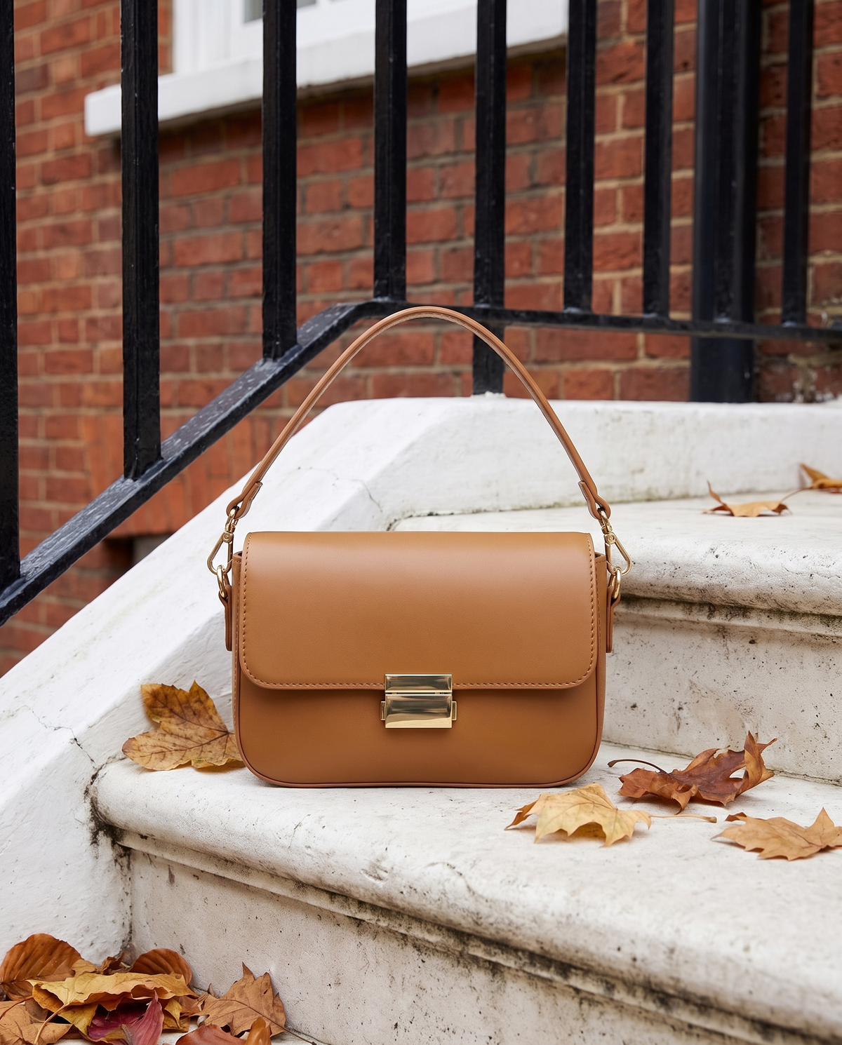 Sac JUNO cognac Maison André posé sur le perron d'une maison londonienne, feuilles d'automne