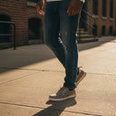 André Kibris kaki canvas and suede low-top sneakers with orange heel tabs and white soles.