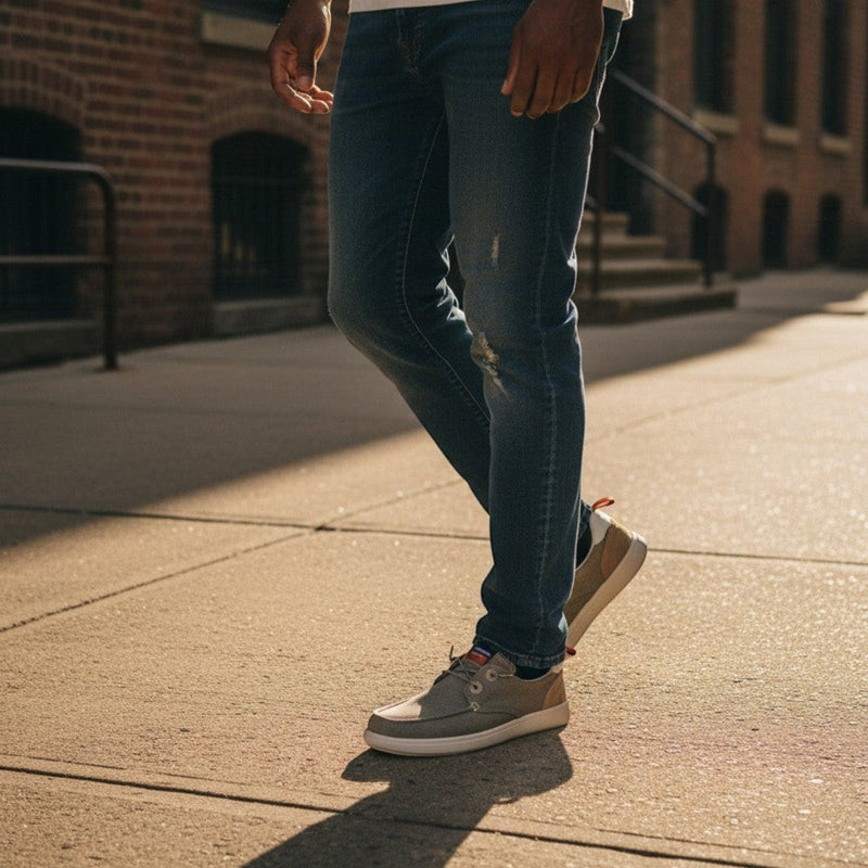 André Kibris kaki canvas and suede low-top sneakers with orange heel tabs and white soles.