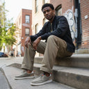 André Kibris kaki canvas and suede moccasin sneakers with orange heel tabs and white soles.