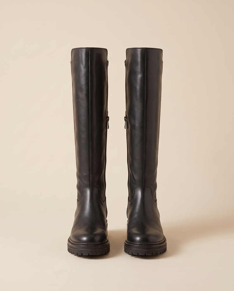 Paire de bottes LALIE noires debout sur fond beige