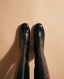 Paire de bottes LEZIA noires imprimé croco vue du dessus sur fond beige — André