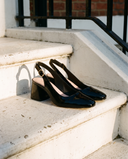 Slingback LOUISE noire posée sur le perron d'une maison londonienne