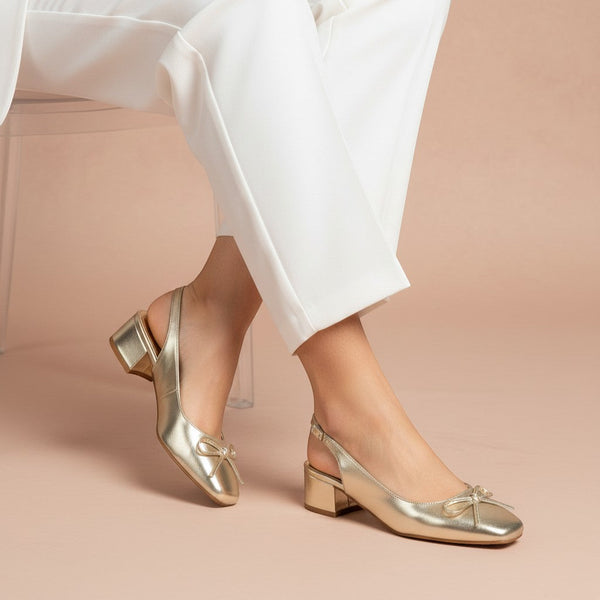 André gold metallic slingback heels with a bow detail and a low block heel.