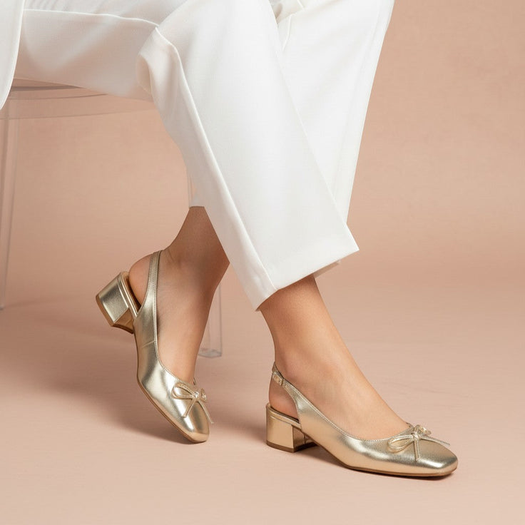 André gold metallic slingback heels with a bow detail and a low block heel.
