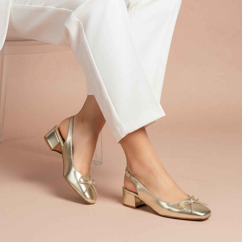 André gold metallic slingback heels with a bow detail and a low block heel.