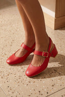 André MONA ROUGE slingback en cuir rouge avec bride à boucle dorée et talon bloc de 5 cm. Style rétro chic.