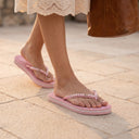 Tongs André NANON ROSE rose clair avec détails perlés sur les brides portées par une femme en extérieur