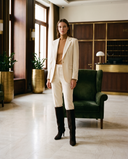 Botte NAWEL marron portée avec un tailleur crème dans un lobby d'hôtel — Stephan x Maison André