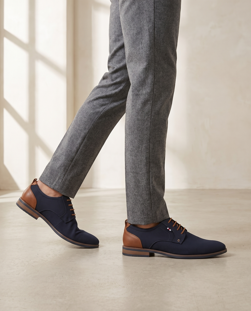 Derby NIGUELAS bleu marine porté, pantalon flanelle gris, sol béton clair
