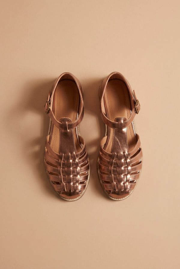 André sandales PETRONILLE en cuir bronze tressé, bout fermé, bride à boucle, semelle plate.