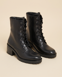 Boots RIHALA noir debout sur fond beige