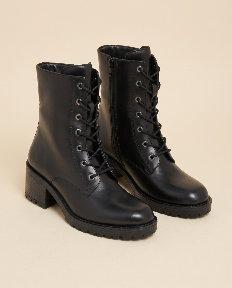 Boots RIHALA noir debout sur fond beige