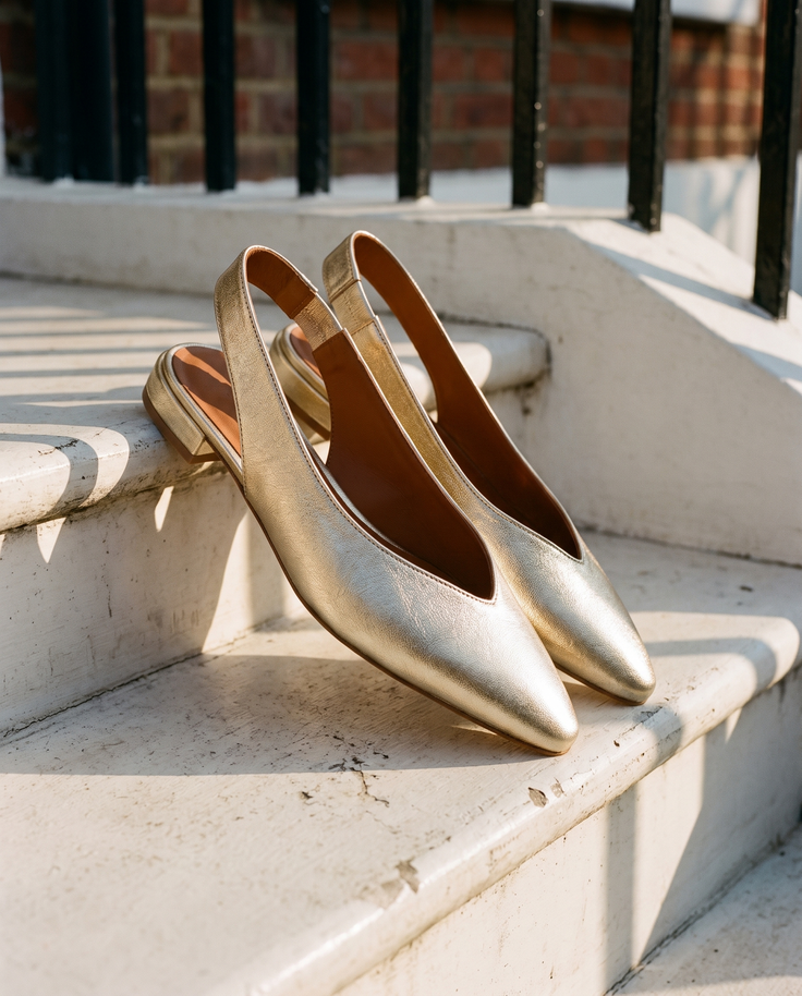 Slingback ROSEE dorée posée sur le perron d'une maison londonienne