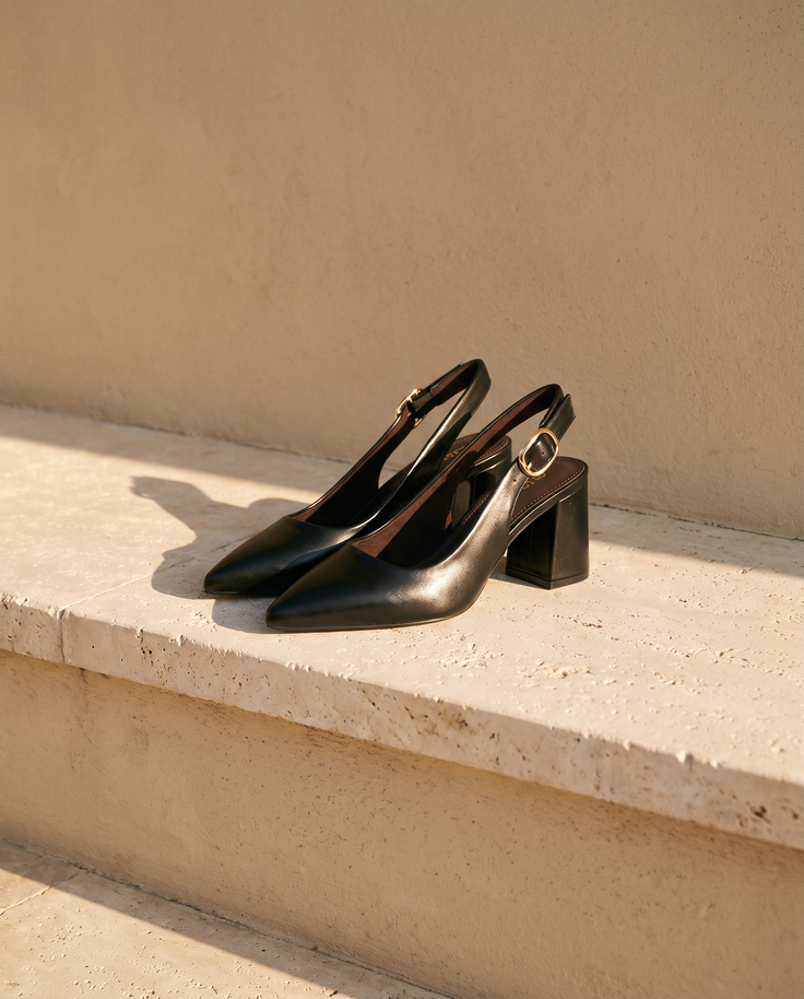Paire de slingbacks THAÏS noirs posée sur une marche en pierre — A by André