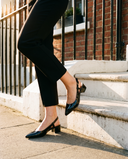 Slingback THALASSA noire portée, gros plan, un pied posé sur la marche d'une maison londonienne