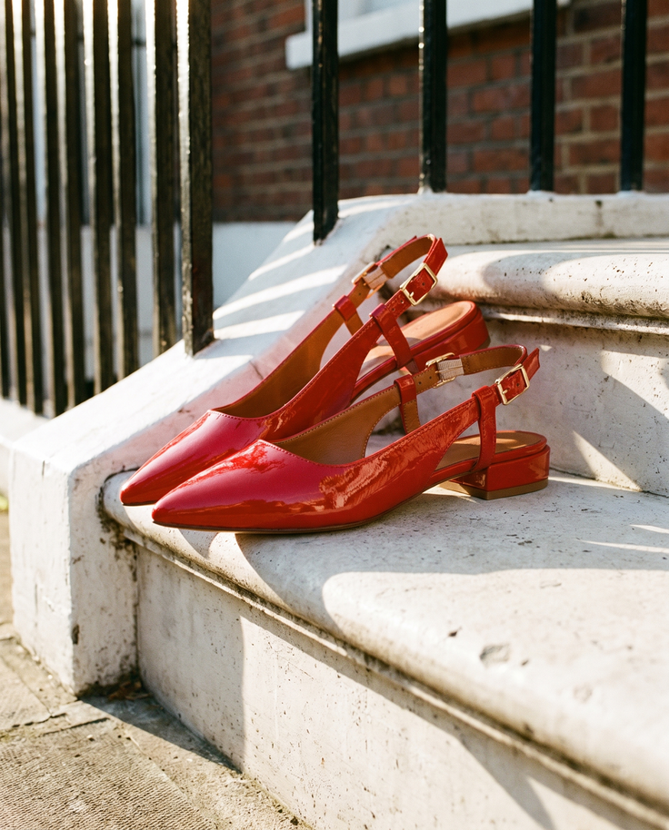 Slingback THALASSA rouge posée sur le perron d'une maison londonienne