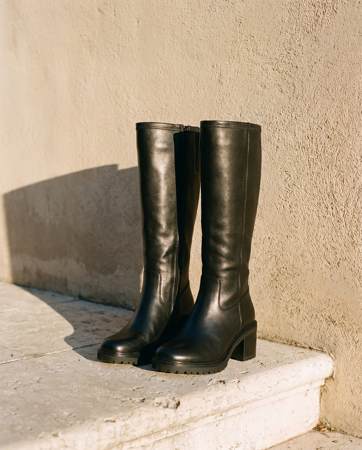 Paire de bottes UMMA noires posée sur une marche en pierre — André